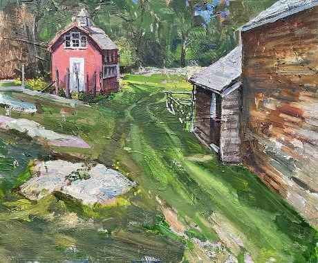 A grassy walkway with two buildings along side it, a red outbuilding and a brown barn.