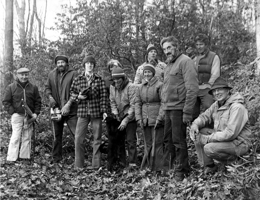 A black and white photo of a group of men standing in a forest.