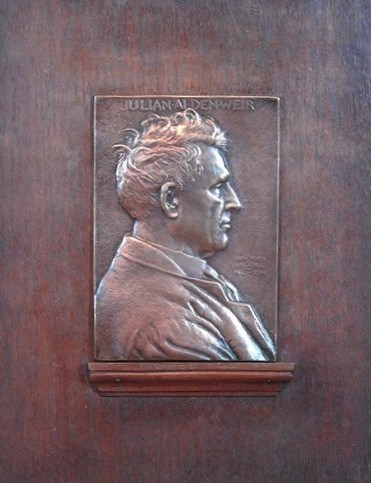 A bronze medal plaque with a side portrait of a man.