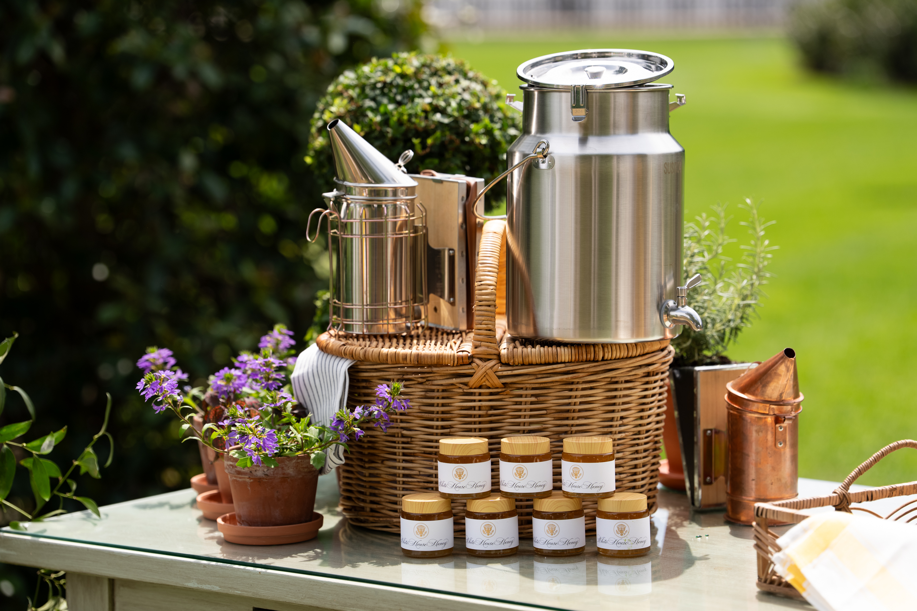 Jars of honey and related items rest on a table in the Kitchen Garden