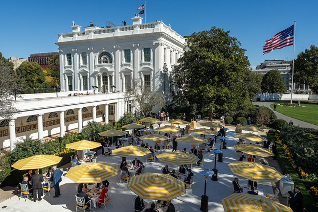View of the Rose Garden patio during a dinner, filled with tables, yellow umbrellas