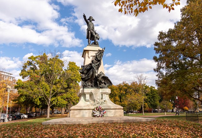 A statue of a man in Revolutionary military garb pointing outward.