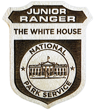 A wooden White House Junior Ranger Badge
