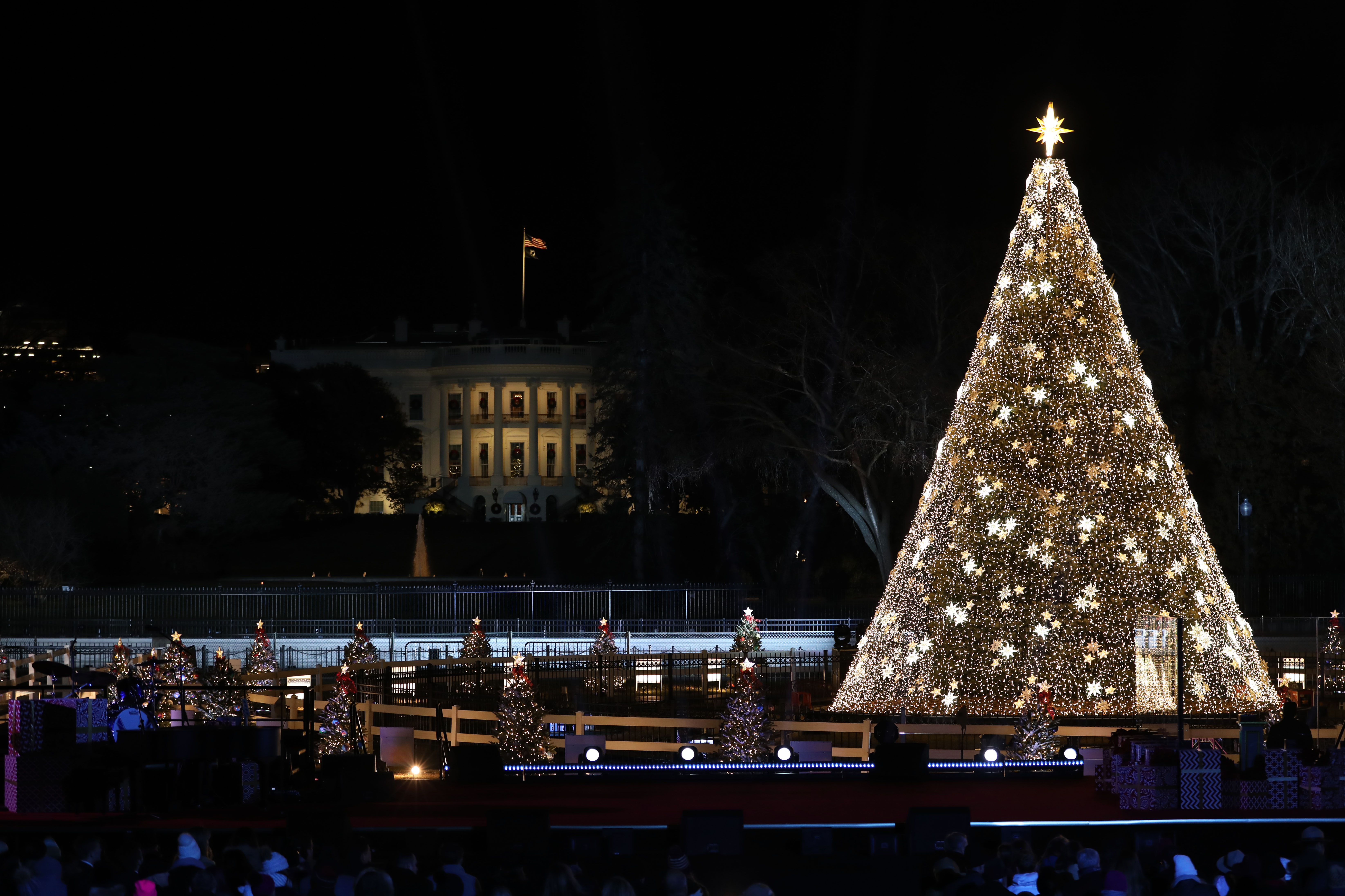 2019 National Christmas Tree decorated with white stars and White House in background 2019 National Christmas Tree decorated with white stars and White House in background