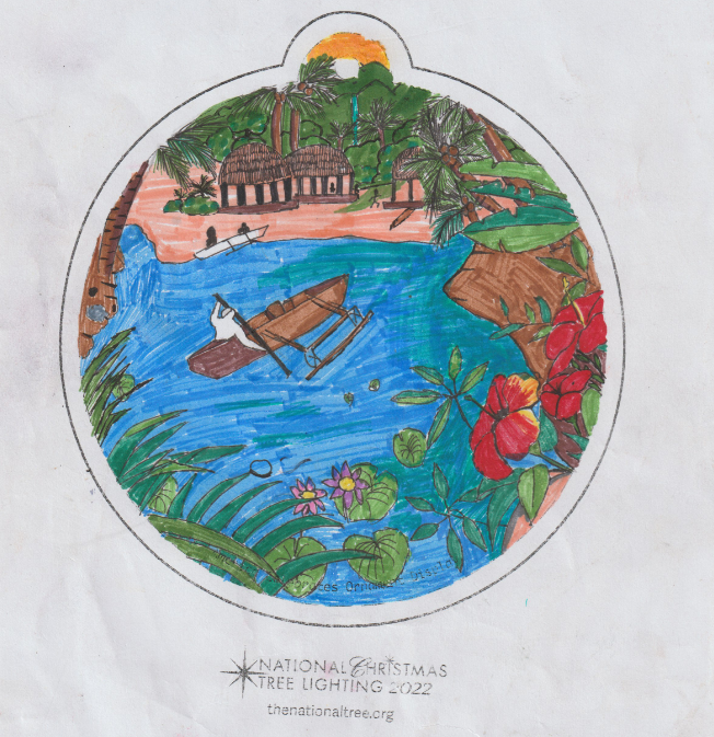 A Christmas tree ornament depicting a tropical coastline surrounded by lush flora. In the water there are people riding in two canoes and there are several houses situated on the land.