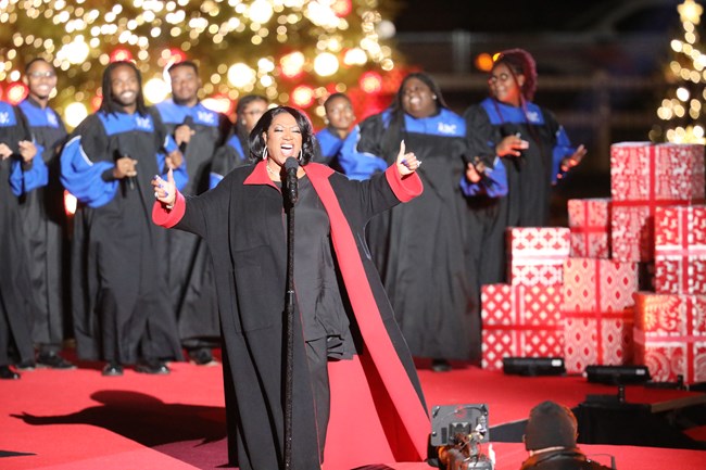 Patti LaBelle sings, backed by the Howard Gospel Choir in front of a huge lit Christmas tree.