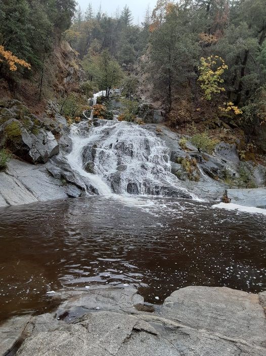 Crystal Creek Falls. A cascading creek dropping into a pool of water amidst boulders and woodland in fall colors.