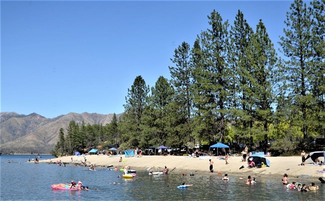 Summertime at Brandy Creek Beach. Visitors swimming, relaxing, and playing in the sand.