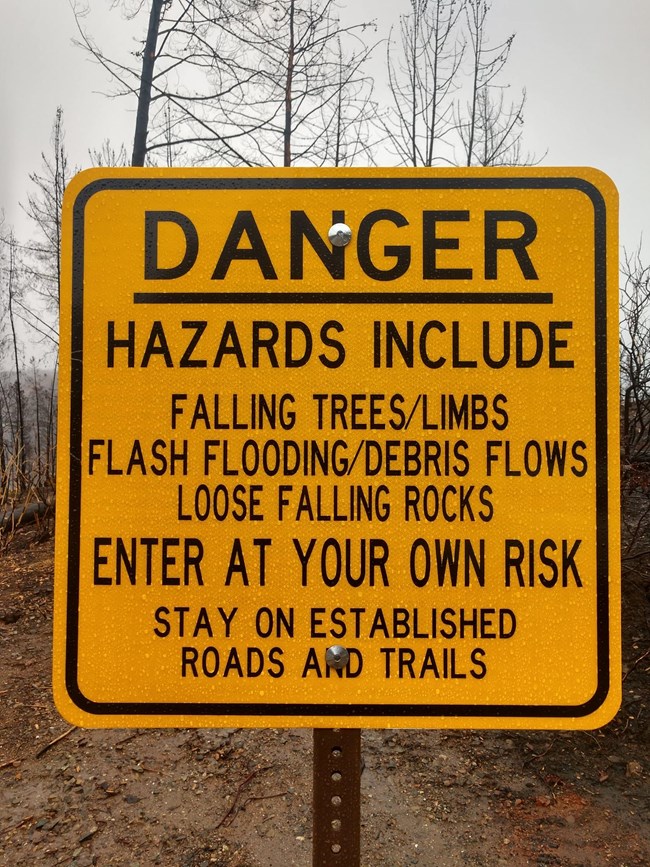 Whiskeytown sign noting some of the dangers of entering the post-fire landscape: falling trees and limbs, loose and falling rocks, flash flooding and debris flows. Enter at your own risk and stay on established roads and trails.