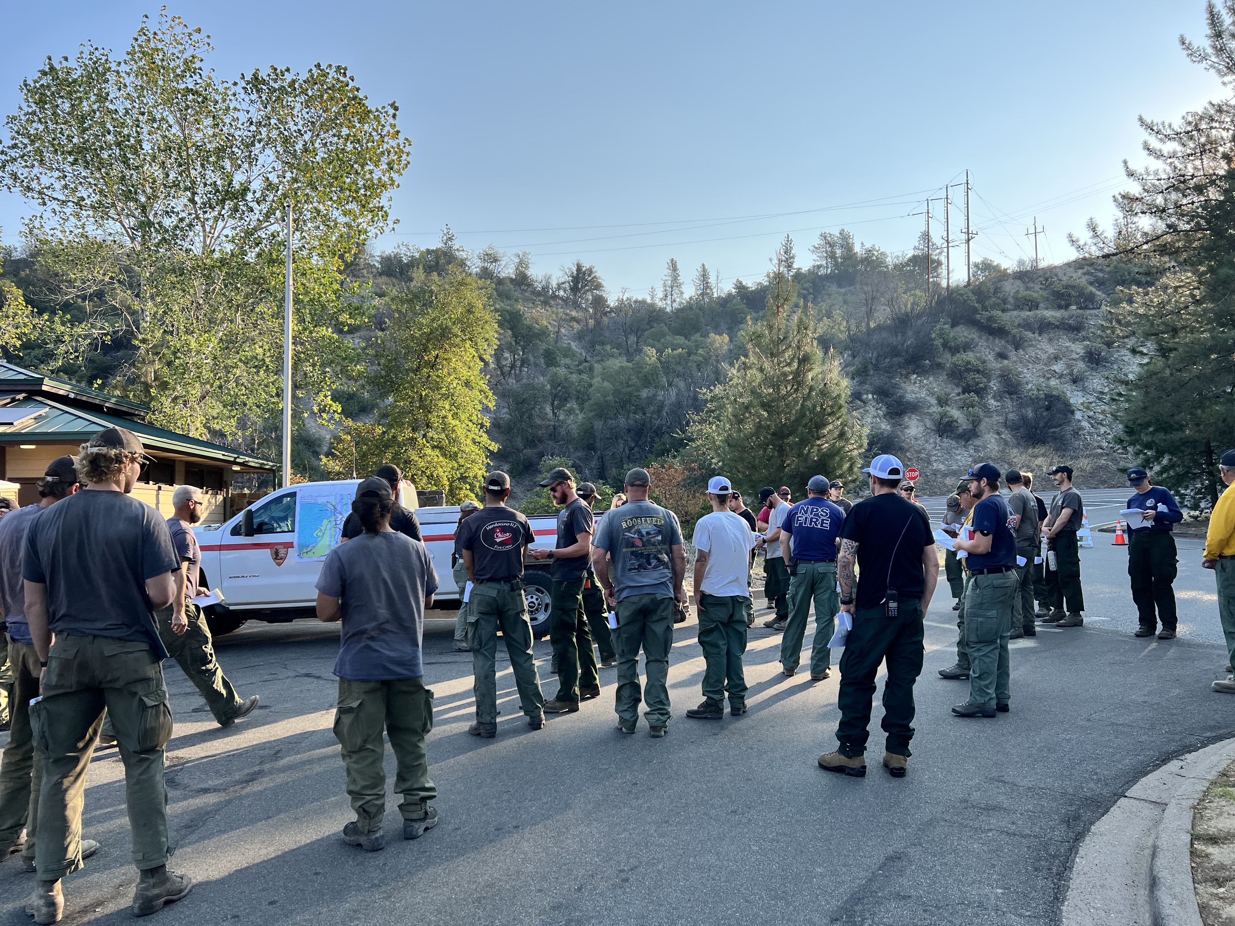 Firefighters from multiple agencies gather for a morning briefing.