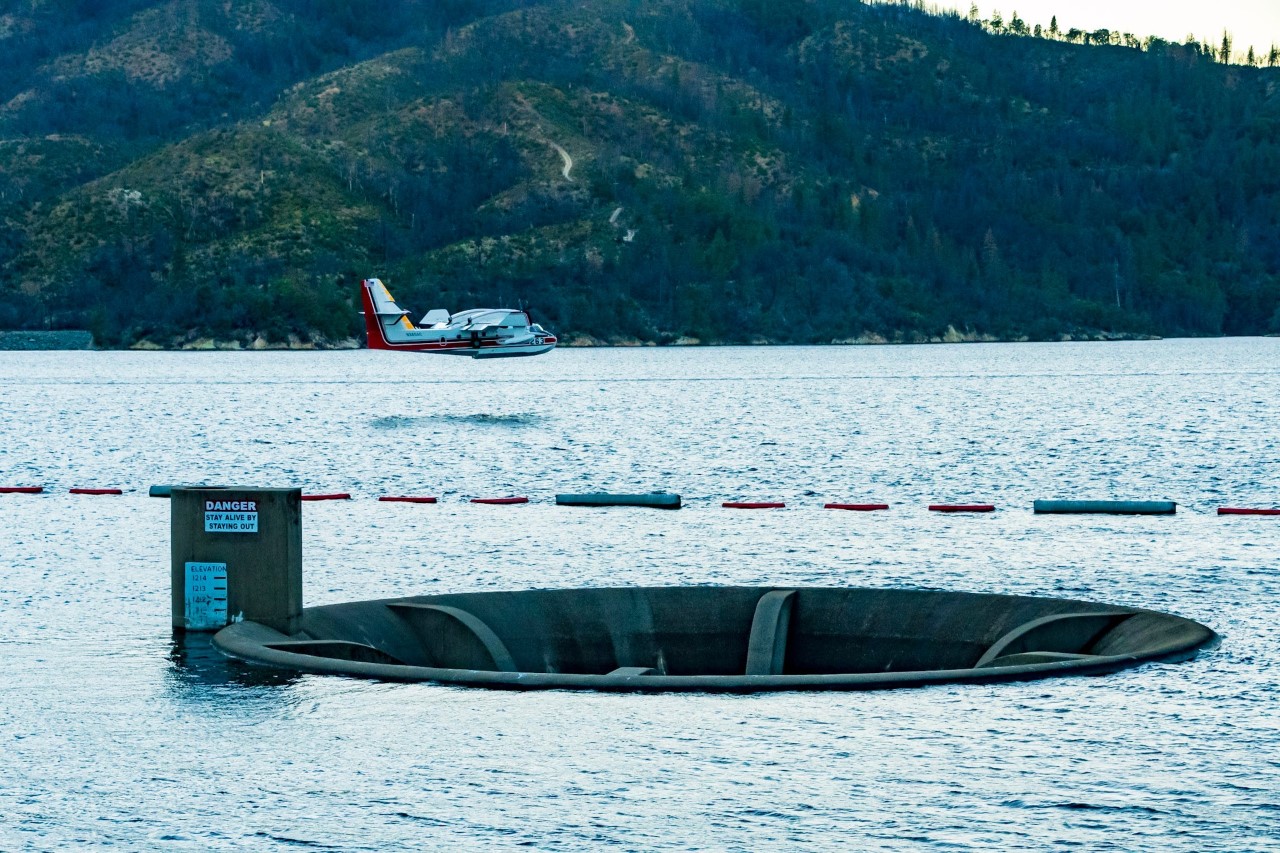 A scooper aircraft scooping water from Whiskeytown Lake to drop on the Zogg Fire. A scooper aircraft scooping water from Whiskeytown Lake to drop on the Zogg Fire.