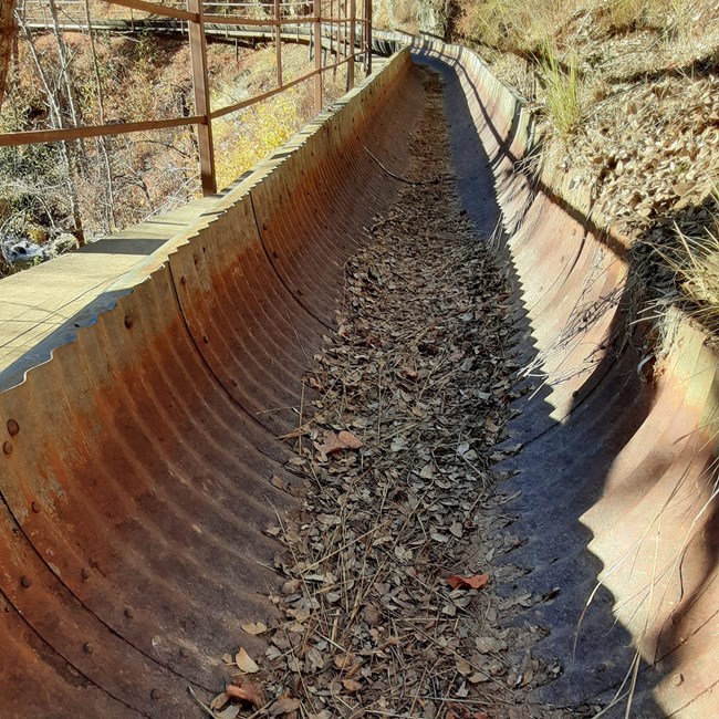 Metal flume and narrow boardwalk section of Crystal Creek Water Ditch and Trail.