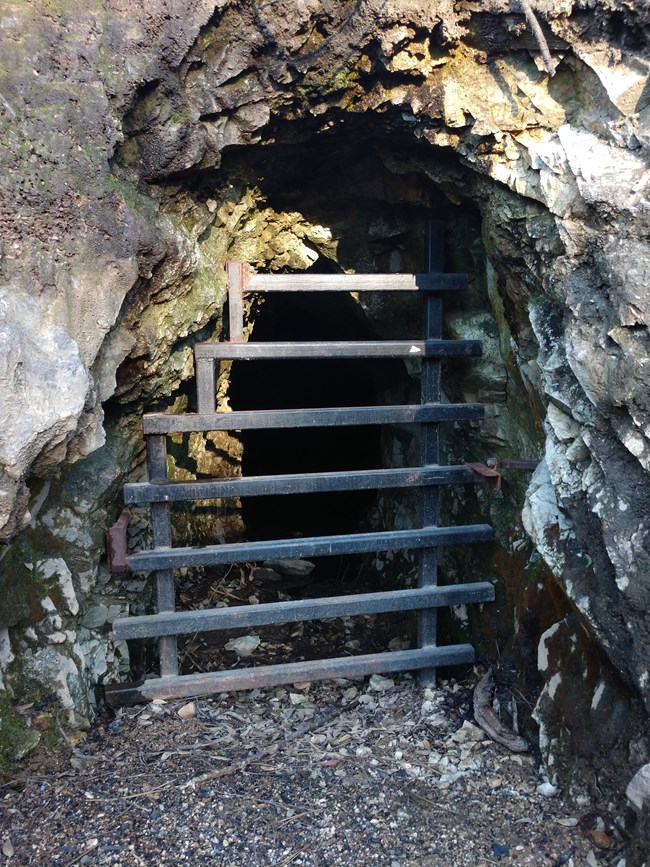 Abandoned mine shaft on Mount Shasta Mine Loop Trail. The entrance is gated to keep visitors out but allow bats to exit and enter.