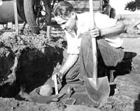 Worker measuring cannon ball before taking it out.