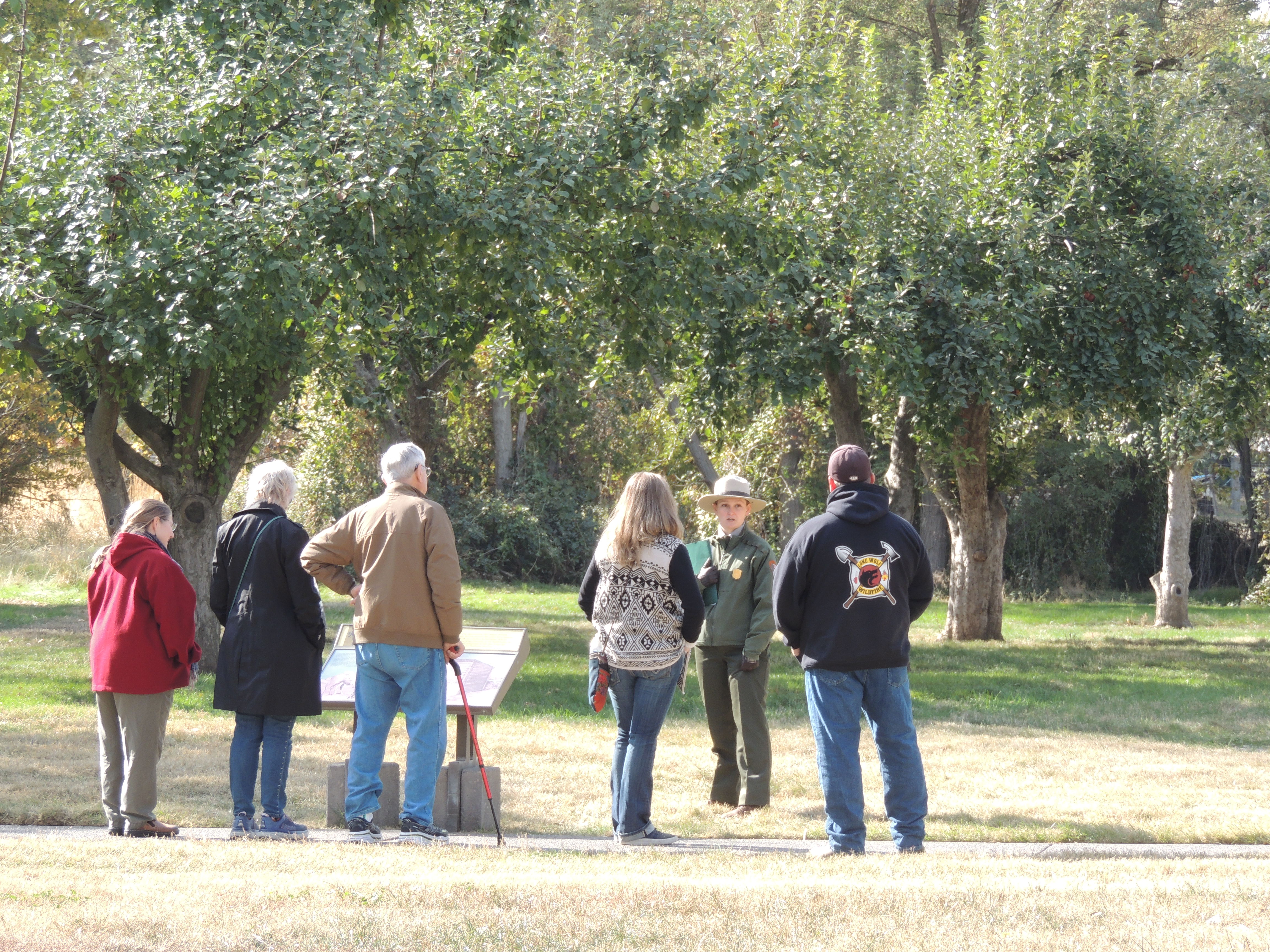 A ranger talking to a group of visitors on a sidewalk path
