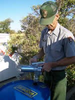 Park ranger standing next to drum filled with biodiesel.