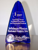 Governor's award: A 10 1/2 tall blue, triangular pies of glass inscribed with award title, state seal, and governor's signature.