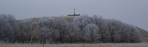 hill with monument on top and frosted trees at base