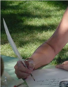 Close-up on hand while using a quill pen. Close-up on hand while using a quill pen.
