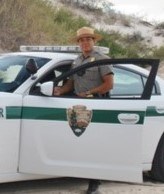 Law enforcement ranger stepping out of a patrol car