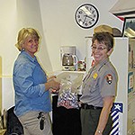 Two women pause from work to smile at the camera