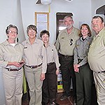 A group of volunteers stand and smile