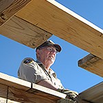 A man looks out over a wooden frame