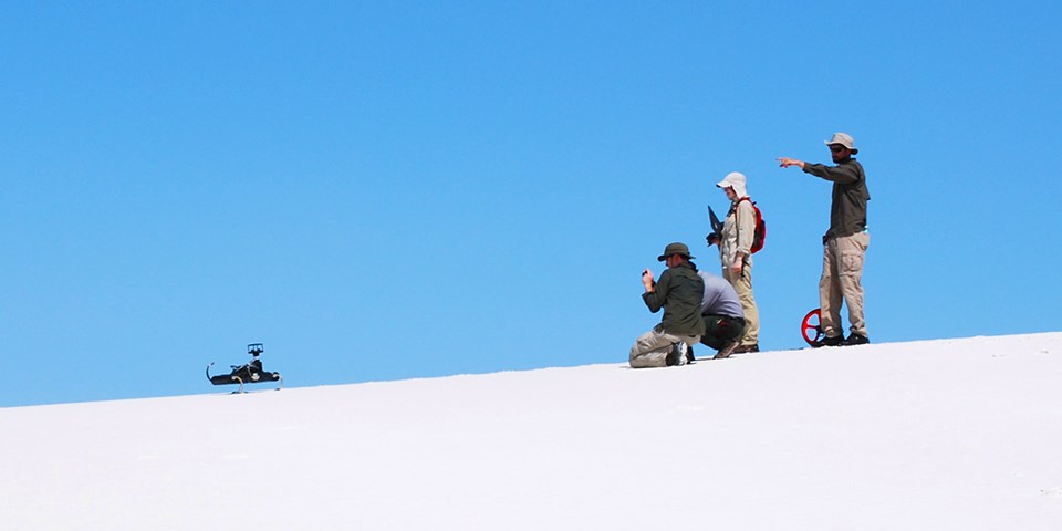 Researchers testing a robot on the dunefield. Researchers testing a robot on the dunefield.