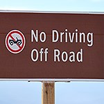 A sign reads “No Driving Off Road”