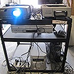 A stand containing technical equipment and a projector