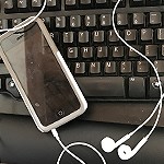 A phone with headphones on a keyboard