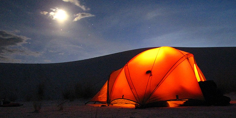 Camping tent out in the backcountry camping loop with a full moon and a dune in the background. Camping tent out in the backcountry camping loop with a full moon and a dune in the background.