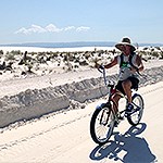 A man with a straw hat riding a bike