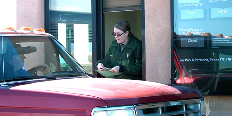 Visitor passing through the fee station and a park ranger attending to him. Visitor passing through the fee station and a park ranger attending to him.