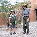 Junior ranger high fiving a park ranger.