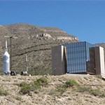 Four story building with white structure in front of mountain range