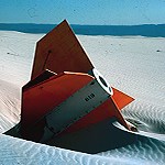 Rear end of an orange missile (UXO) in the dunefield.