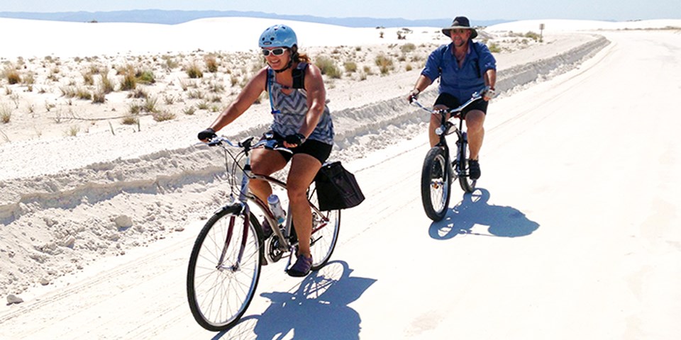 Visitors riding bicycles down dunes drive.