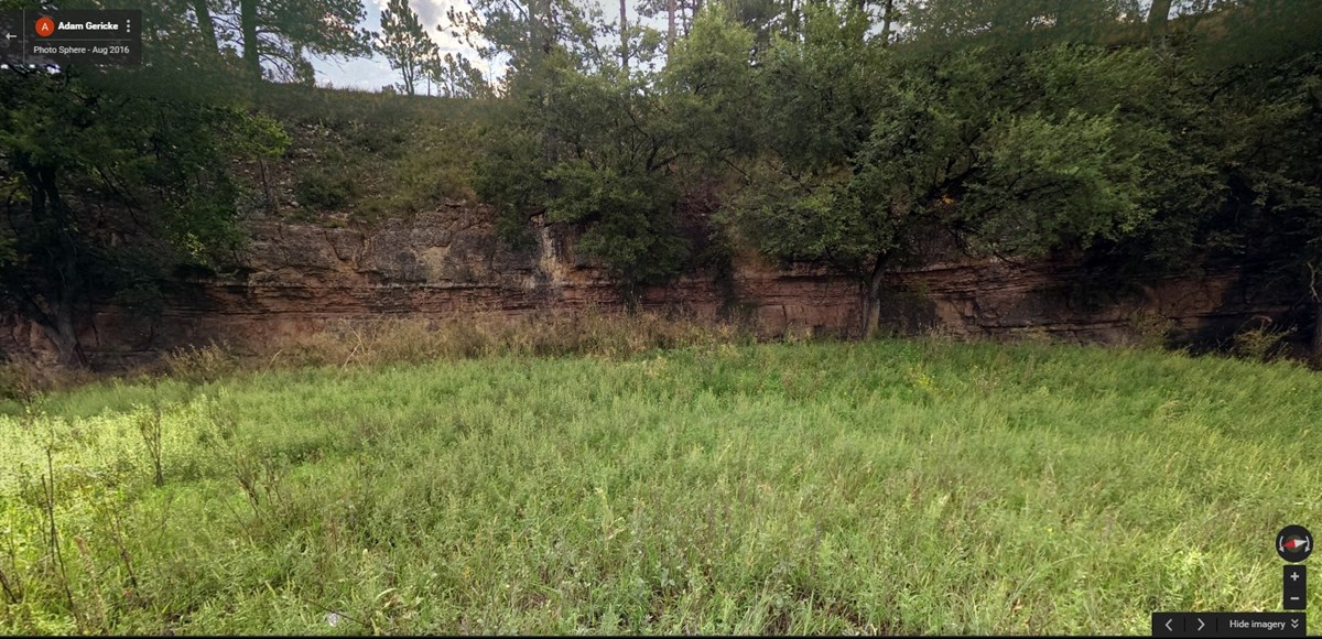 seasonal streambed lined by a red limestone cliff seasonal streambed lined by a red limestone cliff