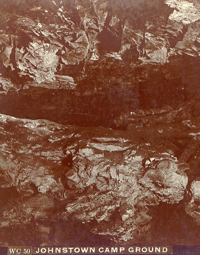 Sepia-toned photograph of a cave room with a ledge in the middle and a ceiling filled with boxwork.