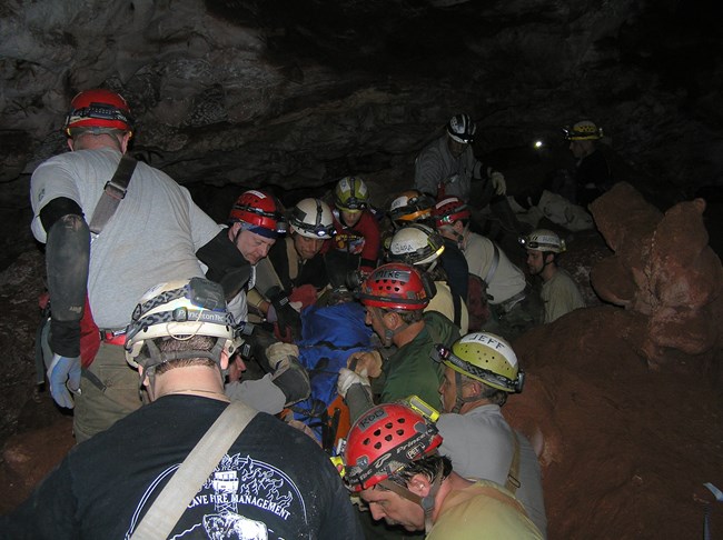 Over a dozen cavers performing cave rescue exercise inside Wind Cave