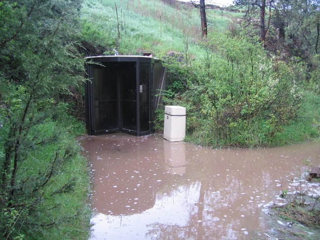 Water accumulated near the walk-in entrance of the cave.