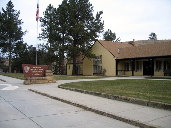Front lawn and entrance to the visitor center with historic sign and flagpole
