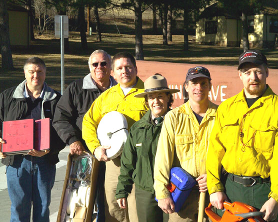 Photo Caption: Displaying examples of equipment bought with grant money are, left to right, Hot Springs Fire Chief Bob Engebretson; Secretary/Treasure of the Hot Springs Fire Department Gerald Hanson; Fire Management Officer Jim McMahill; Park Superintendent Linda L. Stoll; Assistant Fire Management Officer Steve Ipswitch; and Engine Module Supervisor Jason Devcich.