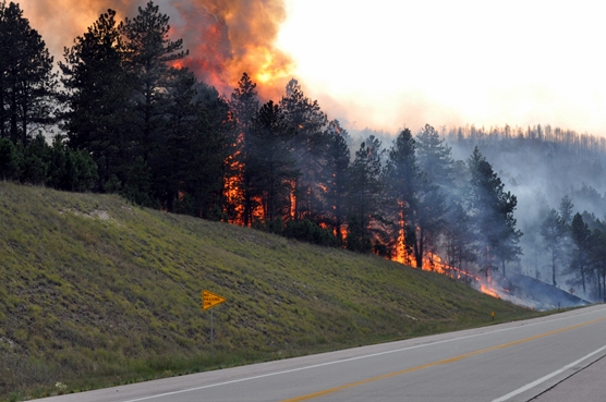 Fire burning up a slope next to Highway 385