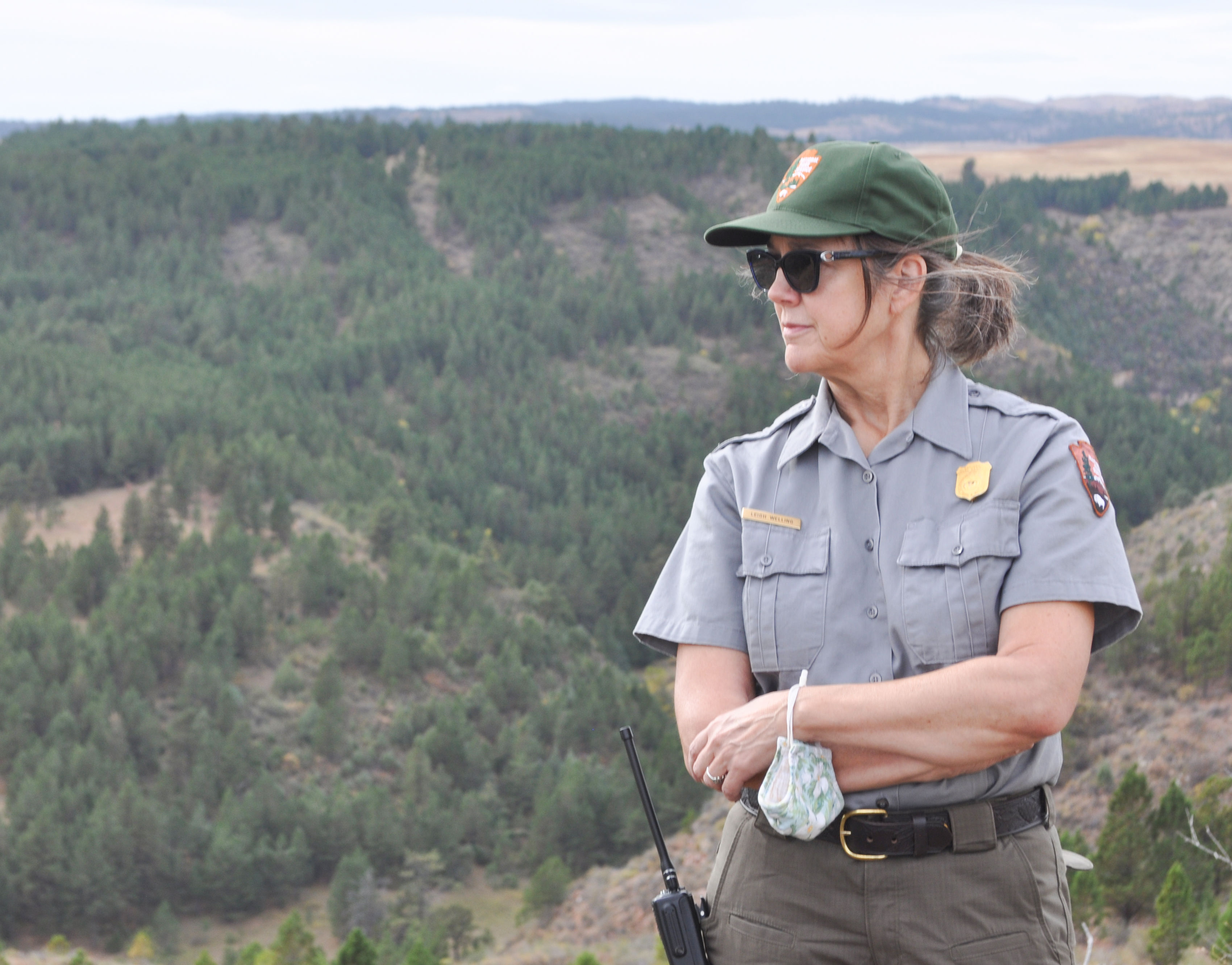 Wind Cave Superintendent Leigh Welling is retiring June 29. Female park ranger looking to the left with a forested canyon behind her.