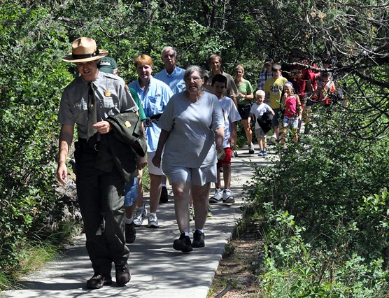 Park Guide Lucas Wassner Leading a Tour along a sidewalk toward the entrance to Wind Cave.