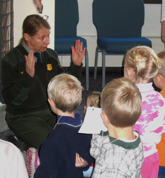 Ranger Mary Laycock kneeling in front of children while giving a program.