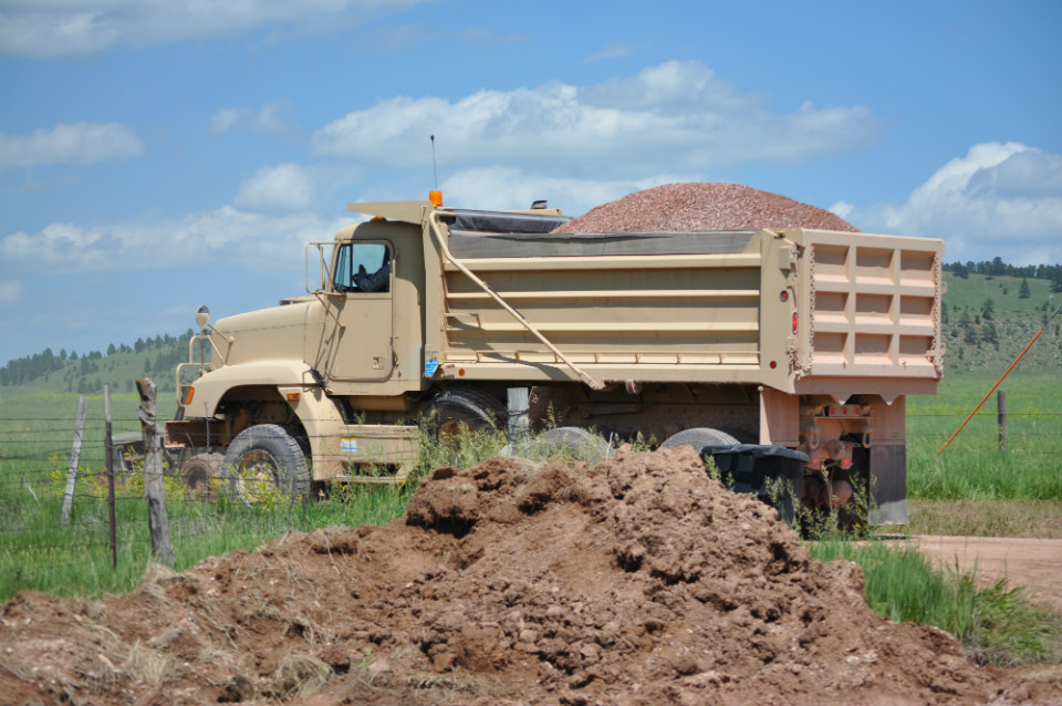 National Guard large truck with a mound of gravel in the back.