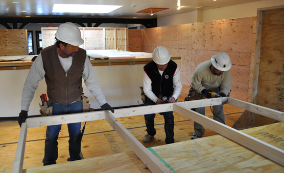 Matt Torrey, Scott Hargens, and Casey Dawson from Horst Acoustical Company, Inc. in Rapid City are constructing a plywood wall to serve as a tunnel during visitor center renovation.